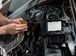 Close up photo of car wrapping specialist putting protective film on a car in detailing service