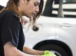 Female mechanic pulling out the weather seal of a vehicle